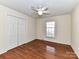 A bright bedroom with hardwood floors, a ceiling fan, and double closet doors for storage at 1098 Woodshire Ct, Rock Hill, SC 29730