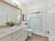 Elegant bathroom features a double vanity, glass shower, and tiled floors at 14407 Brick Church Ct, Charlotte, NC 28277