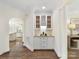 Butler's pantry with granite countertop, wine rack, storage cabinets, and decorative molding at 14407 Brick Church Ct, Charlotte, NC 28277