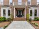 Elegant entryway with double doors, columned porch, bay windows, and meticulously maintained landscaping at 14407 Brick Church Ct, Charlotte, NC 28277