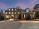 Elegant brick home featuring manicured landscaping, a circular driveway, and classic architectural details at 14407 Brick Church Ct, Charlotte, NC 28277