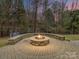Outdoor firepit with circular stone seating at 14407 Brick Church Ct, Charlotte, NC 28277