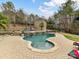 Freeform backyard pool with a stone waterfall feature at 14407 Brick Church Ct, Charlotte, NC 28277