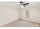 This bedroom is a serene retreat that features a ceiling fan and a large window which gives you a view to the yard at 2401 High Ridge Rd, Charlotte, NC 28270