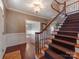 Staircase featuring wood steps, wrought iron spindles, and a decorative chandelier at 25 Blenheim Ne Ct, Concord, NC 28025