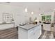 Open concept living area with kitchen island, pendant lighting, stainless appliances, and view to the living room at 404 Killian Ave, Mount Holly, NC 28120