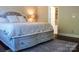 Bright bedroom featuring a cozy bed with drawers, a patterned rug, and a glimpse of the bathroom at 4194 La Crema Dr, Charlotte, NC 28214