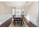 Bright dining room featuring wood floors, a large table, wainscoting, and a chandelier at 4194 La Crema Dr, Charlotte, NC 28214