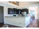Open concept kitchen showcasing dark cabinets, stainless appliances, and a large island with seating for entertaining at 4194 La Crema Dr, Charlotte, NC 28214
