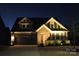Nighttime view of a home showcasing its architectural details and illuminated landscaping at 4929 Norman Park Pl, Clover, SC 29710