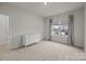 An empty bedroom with a white dresser, neutral carpet, and gray curtains over the large window at 5024 Hillshire Ln, Mint Hill, NC 28227