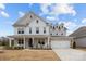 Charming two-story home boasting a covered porch, a two-car garage, and lush landscaping at 5024 Hillshire Ln, Mint Hill, NC 28227