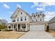 Elegant two-story home with a covered porch, brick accents, and a spacious two-car garage at 5024 Hillshire Ln, Mint Hill, NC 28227