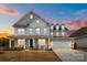 Inviting two-story home featuring a welcoming front porch with a swing and a two-car garage at 5024 Hillshire Ln, Mint Hill, NC 28227