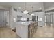 Modern kitchen featuring white cabinets, a spacious island with seating, and pendant lighting at 5024 Hillshire Ln, Mint Hill, NC 28227