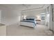 Bright main bedroom with tray ceilings, bedside lamps, large windows, and soft carpet at 5024 Hillshire Ln, Mint Hill, NC 28227