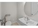 Contemporary powder room featuring a vessel sink, round mirror, and neutral decor at 5024 Hillshire Ln, Mint Hill, NC 28227