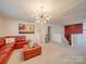 Cozy loft area with a red sectional sofa and a large chandelier at 6029 Landry Ln, Indian Land, SC 29707