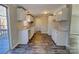 White kitchen cabinets, wood-look floors, and patio access at 6415 Sherwood Ln, Denver, NC 28037