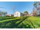 A backyard view of a ranch-style home with a patio surrounded by lush lawn and mature trees at 6835 Ingleside Dr, Sherrills Ford, NC 28673
