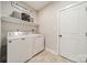 Functional laundry room with washer, dryer, shelving, and tiled flooring at 6835 Ingleside Dr, Sherrills Ford, NC 28673