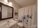 Bathroom features a floral shower curtain and white vanity with countertop at 8065 Stoneham Ct, Matthews, NC 28105