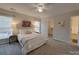 Bedroom features a ceiling fan, windows, carpet floors, and a walk-in closet at 8065 Stoneham Ct, Matthews, NC 28105