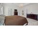 Bright bedroom with tray ceiling, modern lighting, en-suite bathroom, laundry room, and neutral carpet at 10103 Andres Duany Dr, Huntersville, NC 28078