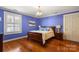 Comfortable bedroom features hardwood floors, blue walls, and a window with shutters at 1335 E Marion St, Shelby, NC 28150
