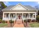 Charming home featuring a welcoming front porch with white columns and a bright red front door at 1335 E Marion St, Shelby, NC 28150