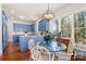 Bright kitchen features blue cabinets, wood countertops, hardwood floors, and a glass dining table with a view at 1335 E Marion St, Shelby, NC 28150