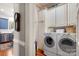 Functional laundry room with white cabinets, modern washer and dryer units, and hardwood flooring at 1335 E Marion St, Shelby, NC 28150