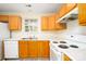 Close up of kitchen featuring white counters, appliances, and oak cabinets at 1748 Pergola Pl, Charlotte, NC 28213
