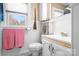 Compact bathroom with white fixtures, vanity, and a window for natural light at 1902 Old Wilkesboro Rd, Statesville, NC 28625