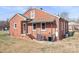 Rear exterior view of a red brick home featuring a covered back porch at 1902 Old Wilkesboro Rd, Statesville, NC 28625