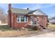 Charming brick home featuring a black awning, chimney, and landscaped garden under a blue sky at 1902 Old Wilkesboro Rd, Statesville, NC 28625