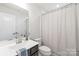Bathroom featuring a single sink vanity, toilet, and shower with white shower curtain at 232 Parkwood Ave, Charlotte, NC 28206