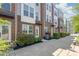Modern brick townhome with manicured landscaping and walkway to front door at 232 Parkwood Ave, Charlotte, NC 28206