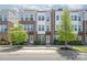 Exterior view of three-story townhomes showcasing a blend of brick and siding, accented by manicured landscaping at 232 Parkwood Ave, Charlotte, NC 28206