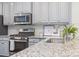 Close-up of kitchen featuring stainless steel appliances, granite countertops, and modern faucet at 232 Parkwood Ave, Charlotte, NC 28206