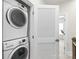 Efficient laundry room featuring stacked washer and dryer, and a slatted door for ventilation and space-saving design at 232 Parkwood Ave, Charlotte, NC 28206