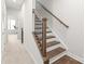 Bright staircase featuring wooden stairs, iron railings, and a window at the top of the stairs at 232 Parkwood Ave, Charlotte, NC 28206