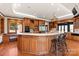 Open kitchen featuring wood cabinets, stainless appliances, hardwood floors and an expansive breakfast bar at 2700 River Ridge Pl, Fort Mill, SC 29708