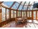 Bright sunroom with wood framed windows, tile floors, ceiling fan and a wood table at 2700 River Ridge Pl, Fort Mill, SC 29708