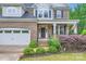 Home exterior showcasing the front porch, door, manicured landscaping, and two-car garage at 2864 Park Ridge Blvd, Rock Hill, SC 29732