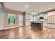 Open concept kitchen and living area with wood floors, stainless appliances, island, and access to the back porch at 2864 Park Ridge Blvd, Rock Hill, SC 29732