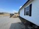 Exterior shot of the house showing the clean white siding, black trim and gravel at 3186 Catawba St, Claremont, NC 28610