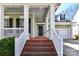 Inviting front porch with brick steps leading to a black front door and offers access to the attached garage at 319 Ohenry Ave, Davidson, NC 28036