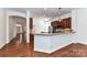 Open kitchen featuring granite countertops, stainless steel appliances, and dark wood cabinets, seamlessly connecting to other living areas at 319 Ohenry Ave, Davidson, NC 28036
