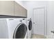 Functional laundry room equipped with modern washer and dryer units, paired with upper cabinet storage at 319 Ohenry Ave, Davidson, NC 28036